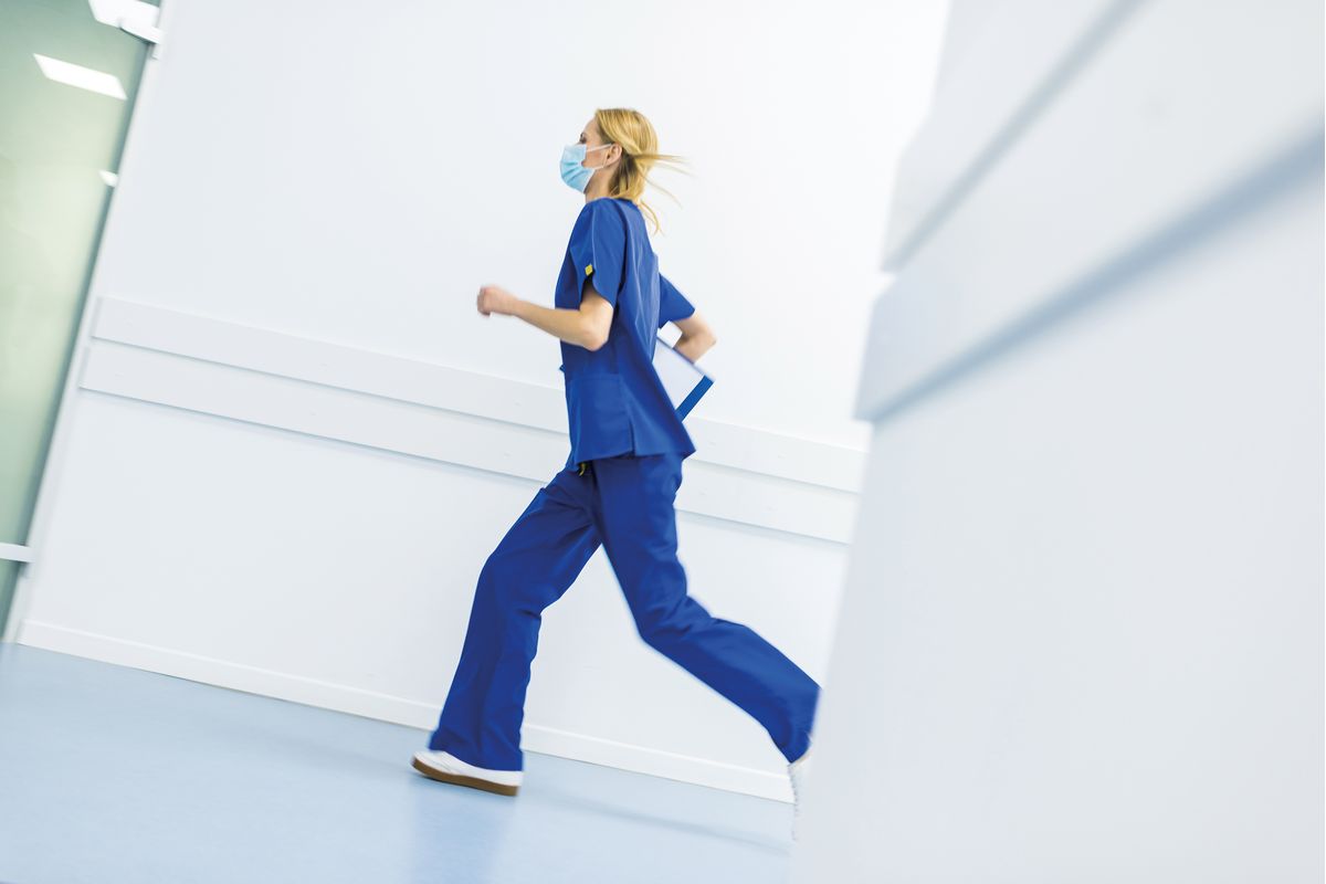 Eine Ärztin läuft eilig in einem Korridor in einem Krankenhaus